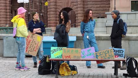 Young-Fridays-for-Future-activists-at-climate-strike-with-colorful-placards,-Stockholm-street-scene,-daytime,-vibrant