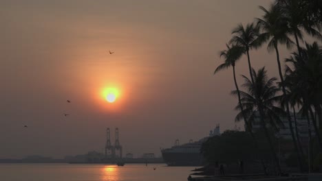 stunning-beauty-of-a-breathtaking-sunrise,-casting-its-golden-glow-over-a-bustling-industrial-and-cruise-port