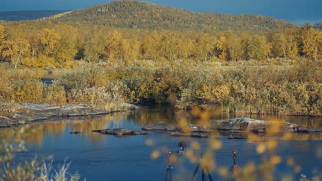 Una-Cámara-Profesional-Montada-En-Una-Plataforma-Deslizante-Está-Colocada-En-La-Orilla-Del-Río-Filmando-El-Paisaje-Otoñal-De-La-Tundra