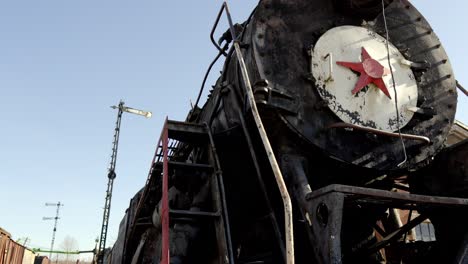 Old-train-engine-with-a-red-star-on-the-front,-camera-pans-down