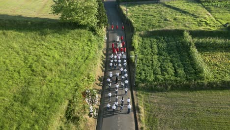 Desfile-Religioso-De-Pascua-Mientras-La-Procesión-De-Personas-Camina-Por-Caminos-Rurales,-Aéreo