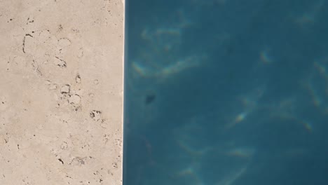 Top-down-shot-of-pool-with-stone-side-frame-and-turqouise-water