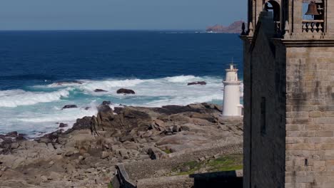 Virxe-da-Barca-Church-On-The-Shore-With-Lighthouse-Revealed-In-Muxia,-Spain
