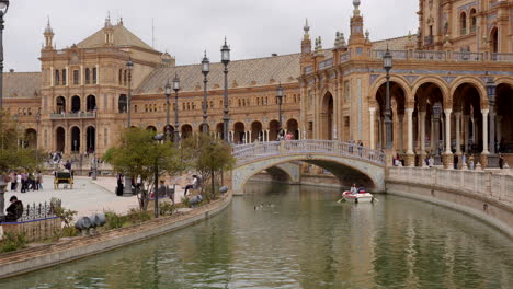 Tourists-Ride-Rowboat-On-The-Canal-Moat-Around-The-Plaza-de-España-In-Seville,-Spain