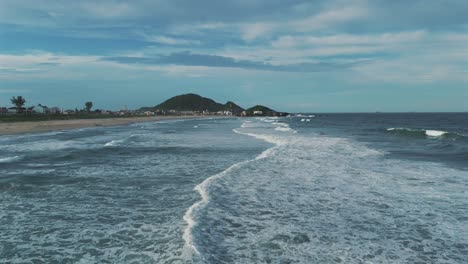 Drone-advancing-over-perfect-waves-at-Praia-Grande-in-São-Francisco-do-Sul,-Brazil