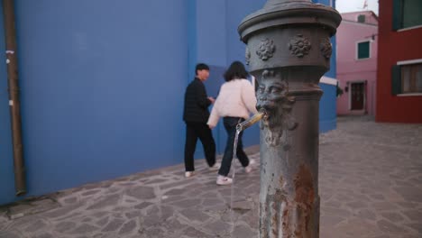 Fuente-Envejecida-Contra-Las-Paredes-Azules-De-Burano