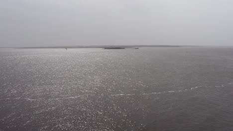 Aerial-low-rising-shot-of-historic-Fort-Sumter-in-Charleston-Harbor-from-Fort-Moultrie-on-Sullivan's-Island-during-a-hazy-day-with-low-visibility-in-South-Carolina