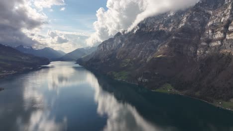 Malerische-Berge-Rund-Um-Den-Ruhigen-See,-Mit-Blauem-Himmel-Und-Wolken,-Die-Sich-Im-Wasser-Spiegeln