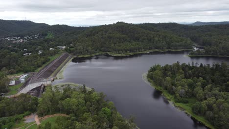 4K-aerial-drone-shot-of-a-water-reservoir-in-Australia-with-green-bushland-around-and-a-concrete-dam-wall