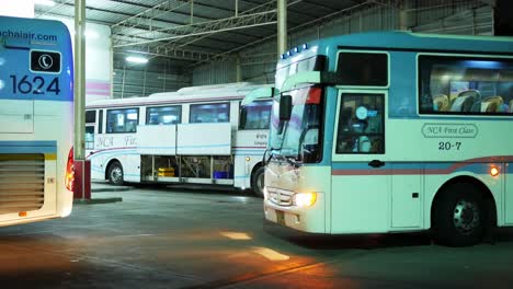 Two-buses-are-parked-in-the-evening-at-a-bus-terminal