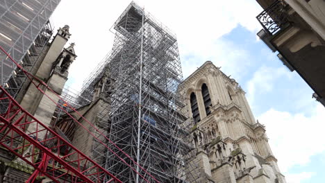 Scaffolds-Attached-to-the-Notre-Dame-in-Paris,-Low-Angle-Tilt-Up