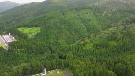 Aerial-reveal-of-pastures,-forest-patches-and-shoreline-in-São-Miguel-Azores