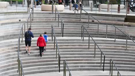 Family-walking-up-the-stairs-outside-of-Battersea-Power-Station,-London,-United-Kingdom