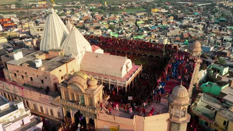 La-Cámara-Del-Dron-Se-Mueve-De-Abajo-Hacia-Arriba-Y-Muchas-Personas-Están-Jugando-Dhuleti-En-El-Templo-Y-Se-Ven-Grandes-Campos-En-Los-Alrededores-Del-Templo-Y-Una-Red-Muy-Conectada.