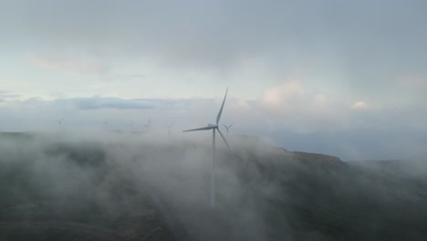 Windräder-Auf-Den-Bergen-Erzeugen-Grüne-Energie,-Umgeben-Von-Wolken-Am-Himmel