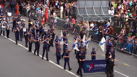 Studenten-Der-Mary-Mackillop-Catholic-College-Band-Spielen-Musikinstrumente-Bei-Der-Anzac-Day-Parade-Mit-Menschenmassen-Säumen-Die-Straße-In-Der-Innenstadt-Von-Brisbane