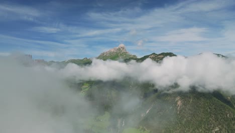 Luftaufnahmen-Einer-Drohne,-Die-Durch-Die-Wolken-Aufsteigt-Und-Den-Peitlerkofel-In-Wolkenverhangenen-Dolomiten-Einrahmt