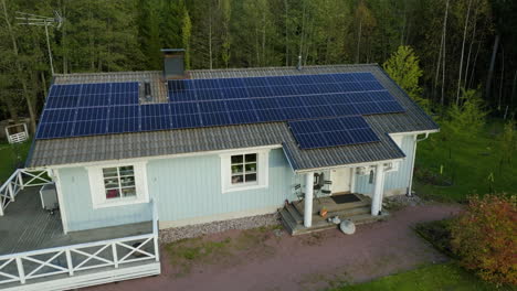 Drone-circling-the-exterior-of-a-eco-friendly-solar-house,-on-a-sunny-fall-evening
