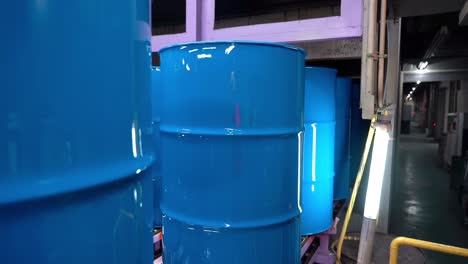 The-steel-drum-cans-gleam-with-a-slow-transfer-blue-paint-after-their-conveyor-ride