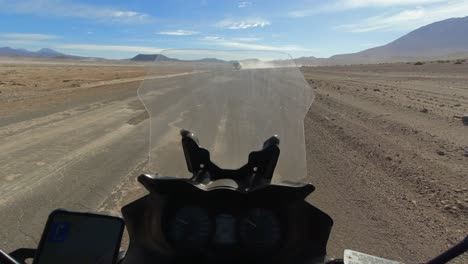 POV-Motorcyclist-meets-tanker-truck-on-dusty-Atacama-desert-road