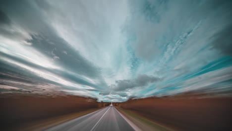Hyperlapse-driving-through-the-windswept-autumn-tundra,-with-dark-clouds-swirling-above-the-road