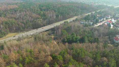 Bustling-freeway-in-between-dense-forest-with-light-haze-from-sun