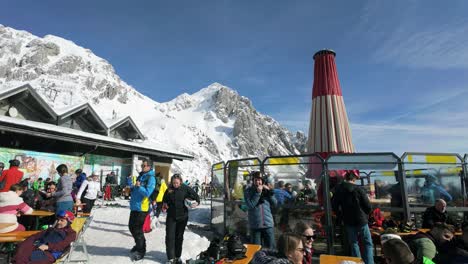 Relaxing-happy-group-of-people-at-one-of-the-mountain-top-eateries-during-ski-season-in-Nassfeld,-Austria