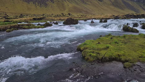 Glacial-River-Under-Volcanic-HIlls-on-Humid-Day-in-Landscape-of-Iceland