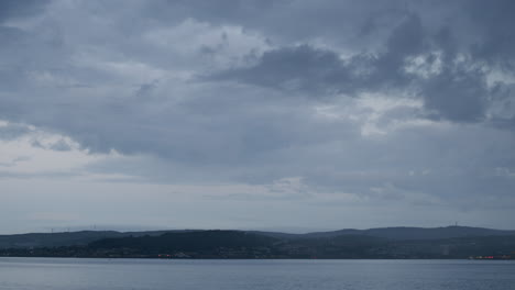 Timelapse-Del-Mar-Y-El-Cielo-Y-La-Ciudad-Distante,-Entra-La-Lluvia