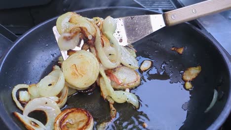 Chopped-White-Onions-Being-Cooked-and-Flipped-in-Pan-Outside