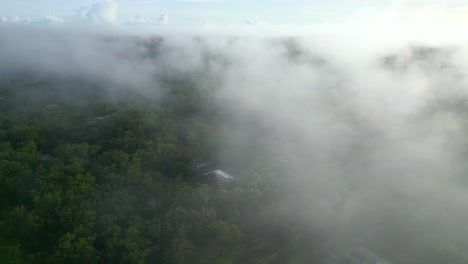 Aerial-Drone-of-Atmospheric-Cloud-Fog-Settling-in-Sky-Above-Rural-Estate,-Orbit