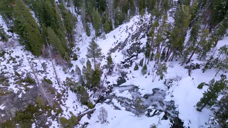 Aerial-pan-up-from-Lower-Eagle-Falls-waterfall-to-Emerald-Bay-on-Lake-Tahoe,-winter