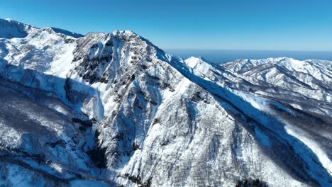 Toma-Aérea-De-Seguimiento-Del-Monte-Myōkō-De-Japón,-En-Un-Claro-Día-De-Invierno,-Una-Montaña-Volcánica-En-La-Región-Del-Parque-Nacional-Myoko-togakushi-Renzan