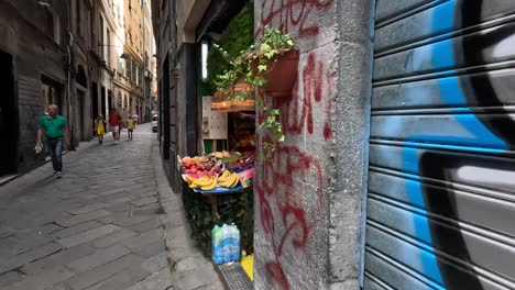 Slow-motion-clip-walking-down-quiet-street-showing-graffiti-style-street-art-and-fresh-fruit-in-open-fronted-shop