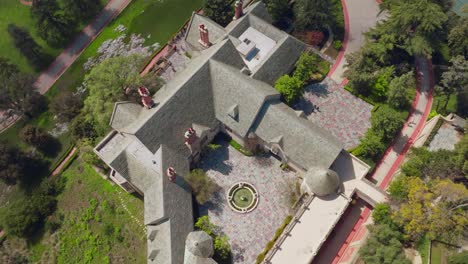 Aerial-Birds-Eye-View-Shot-of-Historic-Greystone-Mansion-in-Beverly-Hills,-California-on-Sunny-Day