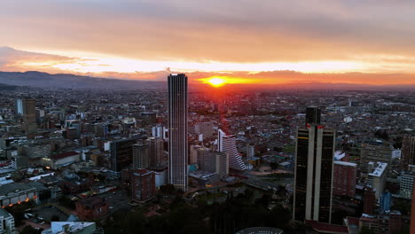 Drone-flying-backwards-through-downtown-Bogota,-vivid-evening-in-Colombia