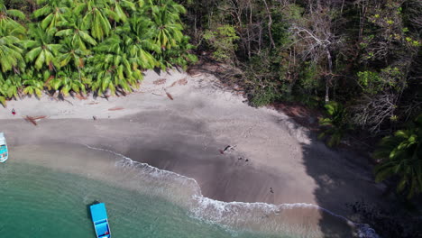 Aerial-establishing-shot-of-a-woman-walking-along-a-beach-at-Cebaco-Island