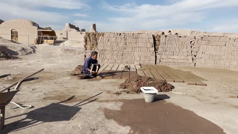 Worker-making-clay-brigs-at-Bam-Citadel,-Iran