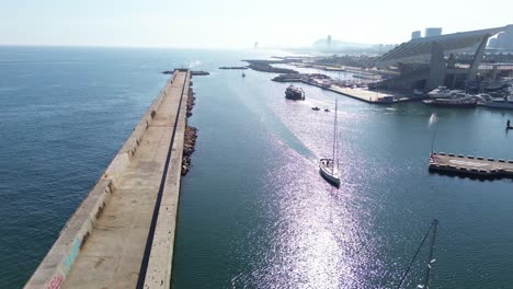 Drohnenaufnahme-Eines-Segelbootes,-Das-An-Einem-Sonnigen-Tag-In-Den-Hafen-Von-Barcelona-Einläuft