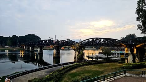 Sonnenuntergangsansicht-Der-Historischen-Brücke-über-Den-Fluss-Kwai,-Berühmt-Geworden-Durch-Einen-Film,-Der-Auf-Der-Herstellung-Der-Todeseisenbahn-Basiert,-Die-Myanmar-Und-Thailand-Während-Des-Zweiten-Weltkriegs-Verband