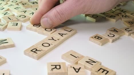 Words-ROYAL-and-SCAM-formed-in-crossword-on-table-top,-Scrabble-game