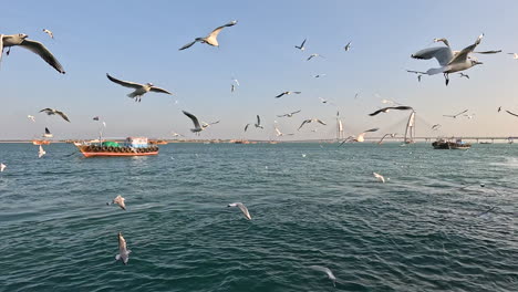 La-Escena-Panorámica-De-La-Bahía-Muestra-Barcos-Anclados,-Un-Puente-Fresco-Y-Un-Muelle-Concurrido-Con-Lugareños-Esperando-Barcos,-Capturando-La-Esencia-De-La-Próspera-Comunidad-Costera.