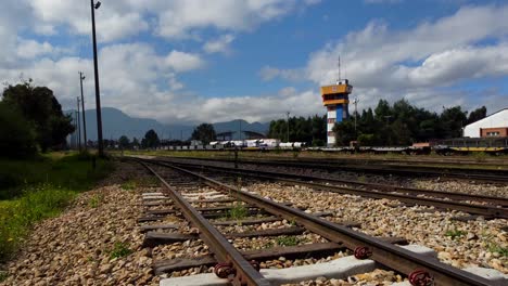 Flight-over-the-iconic-railroad-running-through-the-heart-of-Ciudad-Salitre,-Bogotá,-Colombia