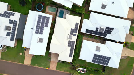 Eine-Von-Oben-Herab-Fliegende-Drohne-Senkt-Sich-Auf-Häuser-Mit-Sonnenkollektoren-Auf-Dem-Dach-Und-Einem-Kleinen-Pool-Im-Hinterhof