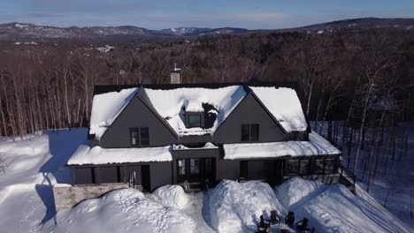 Aerial-shot-of-a-snow-covered-Luxury-Chalet-in-winter-slowly-rotating