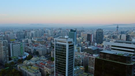 Aerial-view-flying-low-over-the-of-Santiago-de-Chile,-during-a-colorful-dawn