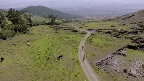 Drone-shot-of-couple-of-bikers-riding-on-mountains-during-daytime