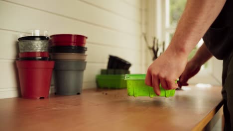 Gardener-Prepares-Rectangular-Plastic-Pot-For-Planting-In-Greenhouse