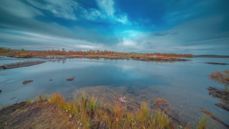 Las-Nubes-Que-Se-Mueven-Rápidamente-Se-Mueven-En-El-Cielo-Sobre-El-Río-Poco-Profundo-Con-Bancos-Cubiertos-De-Bosques-Que-Fluyen-A-Través-De-La-Tundra-Finlandesa.