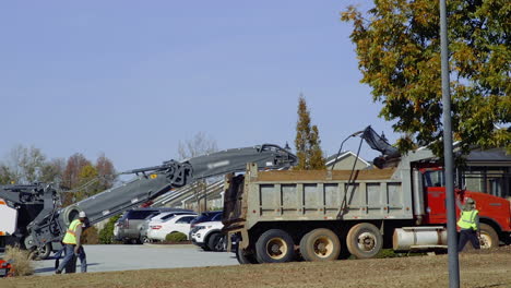 Dump-truck-being-loaded-with-debris-and-moved-by-city-public-utility-workers-during-a-bright-Autumn-day